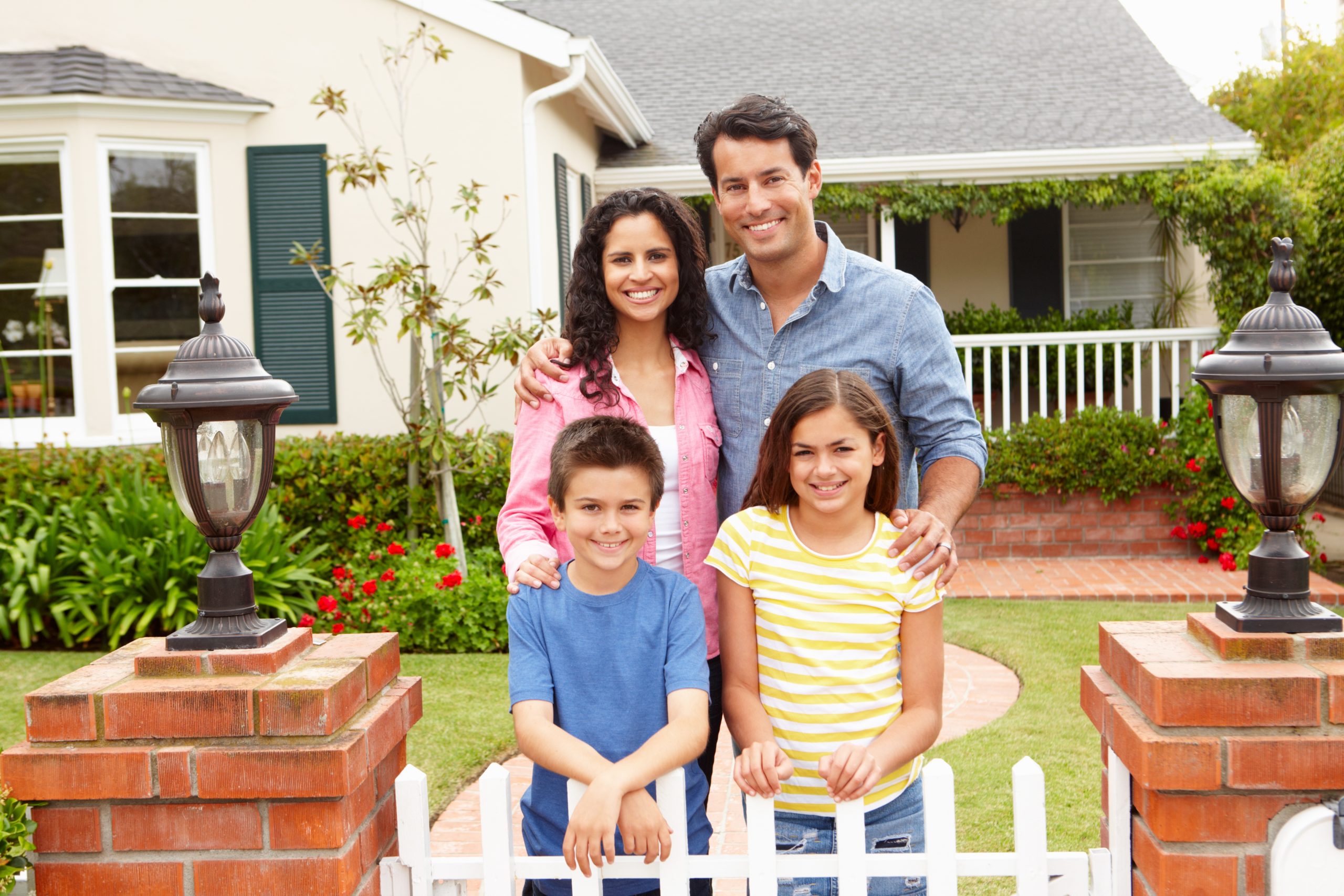 young family standing in front of house