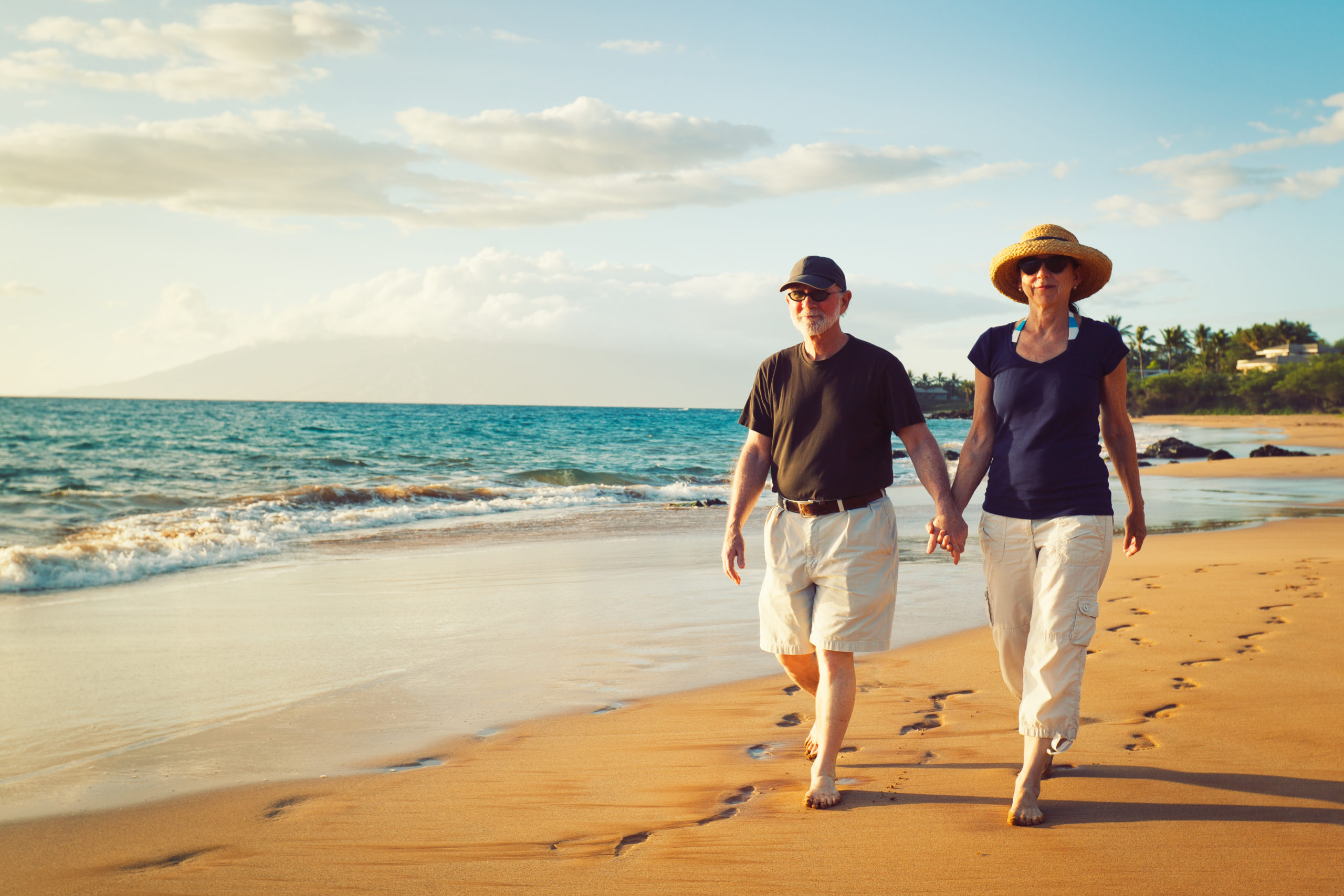 senior couple walking on beach
