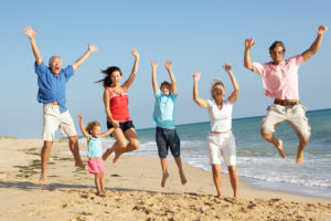 family jumping on beach