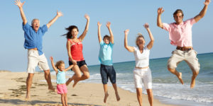 family jumping on beach